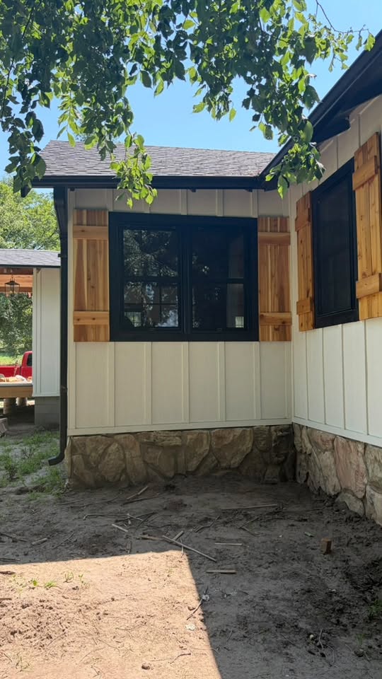 New exterior wood shutters installed around a window